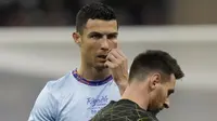 Pemain Paris Saint-Germain (PSG), Lionel Messi bersama pemain Riyadh All-Star, Cristiano Ronaldo, pada laga persahabatan di Stadion Raja Fahd pada Jumat (20/1/2023). Duel Riyadh All-Star XI vs PSG sejak awal memang menjadi ajang reuni antara Ronaldo dan Messi yang selama lebih dari satu dekade terakhir jadi rival sengit. (AP Photo/Hussein Malla)