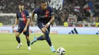 Pemain Paris Saint-Germain (PSG), Kylian Mbappe menggiring bola saat melawan Lyon pada laga pekan keempat Ligue 1 2023/2024 di Groupama Stadium, Senin (04/09/2023). PSG menang dengan skor 4-1. (AP Photo/Laurent Cipriani)