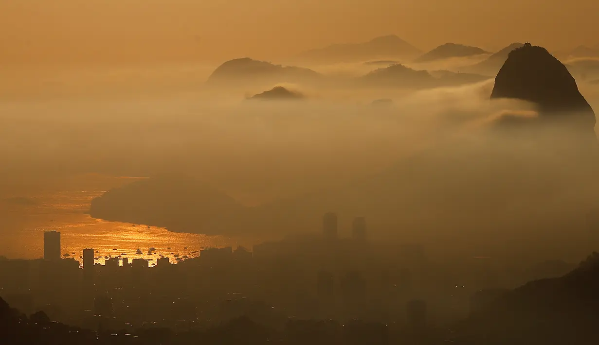 Pemandangan gunung Sugarloaf yang sebagian diselimuti awan tipis saat matahari terbit di Rio de Janeiro, Brasil, 4 mei 2016. Kota Rio de Janeiro akan menjadi tuan rumah Olimpiade 2016 dalam waktu dekat ini. (REUTERS/Ricardo Moraes)