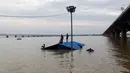 Warga memanjat atap rumah saat terjebak banjir di Allahabad, India (21/8). Banjir bandang menerjang sejumlah wilayah di India yang menyebabkan banyak warga yang terjebak. (REUTERS/Jitendra Prakash)
