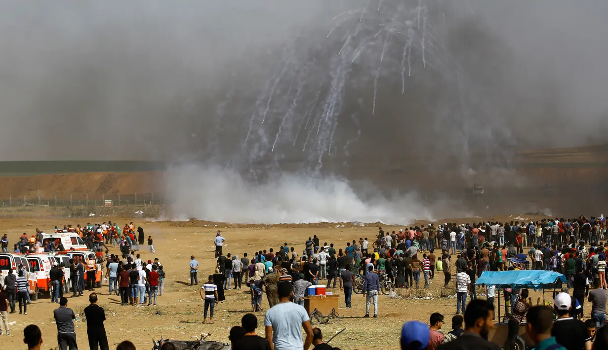 Pasukan Israel menembakkan gas air mata ke arah demonstran Palestina selama bentrokan di perbatasan jalur Gaza (11/5). Sejak aksi digelar kembali pada 30 Maret 2018, sekitar 50 warga Palestina telah tewas oleh tembakan Israel. (AFP Photo/Mohammed Abed)