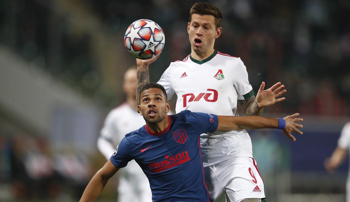 Bek Atletico Madrid, Renan Lodi, berebut bola dengan penyerang Lokomotiv Moscow, Fedor Smolov, pada laga lanjutan Liga Champions 2020/2021di Stadion Lokomotiv, Rabu (4/11/2020) dini hari WIB. Atletico Madrid bermain imbang 1-1 melawan Lokomotiv Moscow. (AFP/Maxim Shemetov/pool)