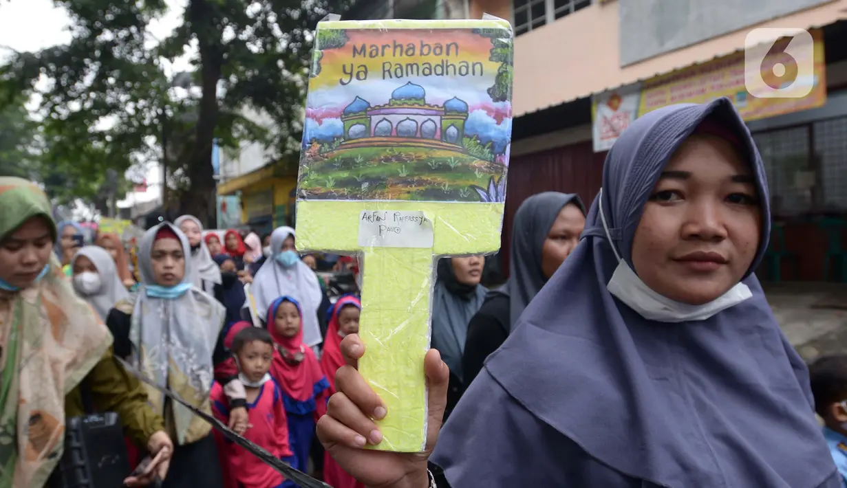 Orangtua murid TK Islam berjalan bersama sambil membawa poster di Jalan Raya Radjiman Widyo Ningrat, Jakarta, Sabtu (26/3/2022). Pawai menyambut datangnya bulan suci Ramadan 1443 Hijriah ini diikuti puluhan murid TK Islam dari berbagai sekolah. (merdeka.com/Imam Buhori)