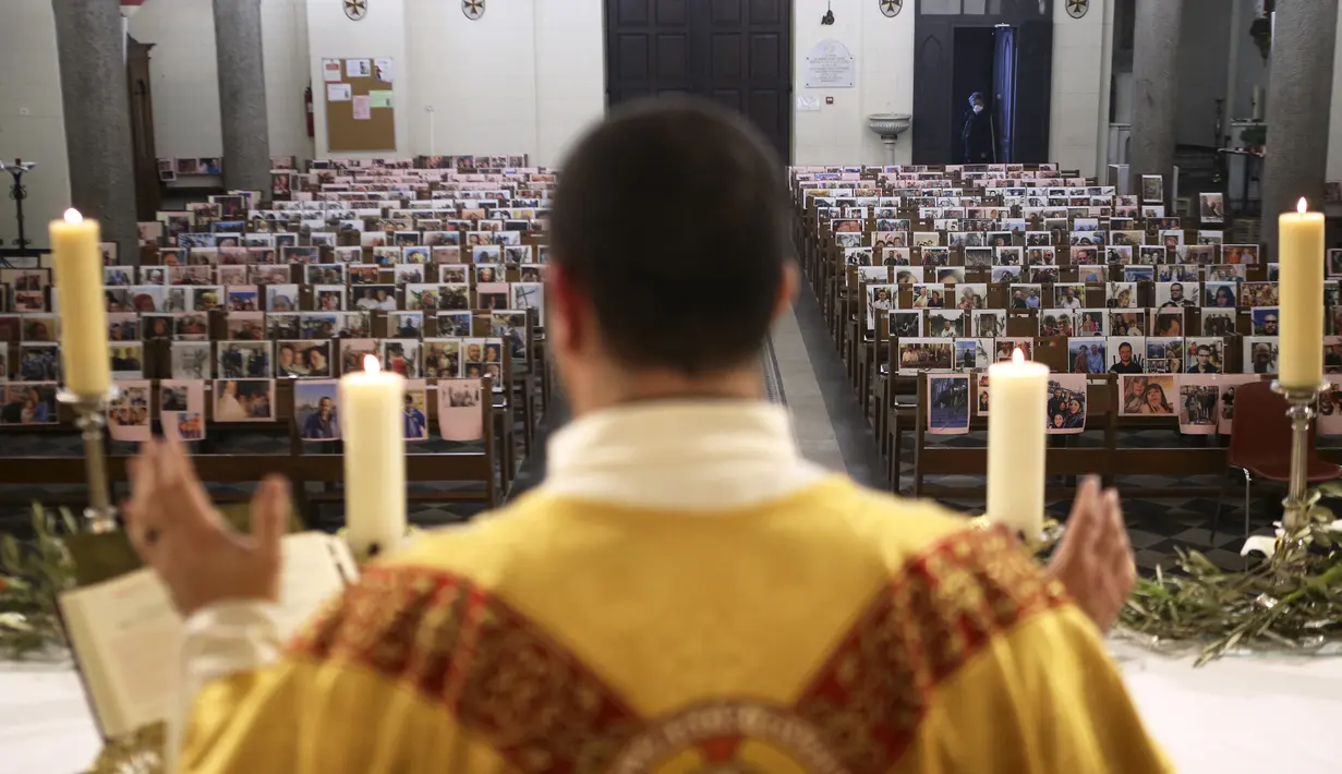 Pastor Katolik Georges Nicoli memberikan khotbah saat merayakan misa Kamis Putih tanpa dihadiri jemaat di Bastia, di pulau Korsika Mediterania, Prancis (9/4/2020). Ibadah misa Kamis Putih ini terlihat hanya foto-foto para jemaat yang ditempel di bangku kosong.  (AFP/Pascal Pochard-Casabianca)