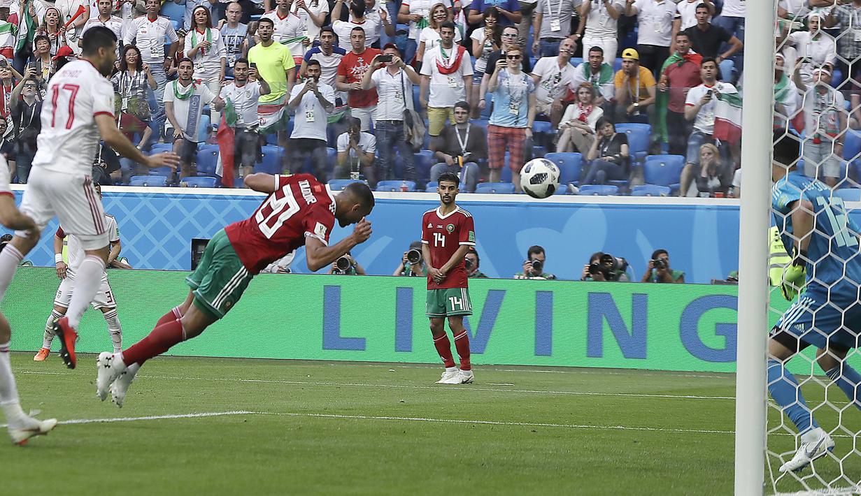 Pemain Moroko, Aziz Bouhaddouz (20) melakukan gol bunuh diri saat melawan Iran pada laga grup B Piala Dunia 2018 di St. Petersburg Stadium, Rusia, (15/6/2018). Iran menang 1-0. (AP/Themba Hadebe)
