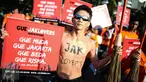Seorang anak muda berpartisipasi dalam aksi simpatik mendukung Wali Kota Surabaya Tri Rismaharini maju sebagai cagub pada Pilkada DKI 2017, di Bundaran Patung Kuda, Jakarta, Minggu (31/7). Mereka membawa simbol sapu lidi. (Liputan6.com/Faizal Fanani)