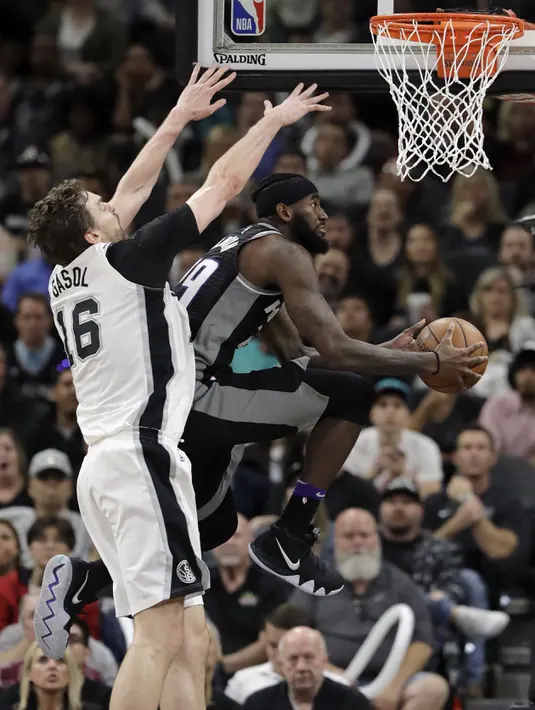 Aksi pemain Sacramento Kings, JaKarr Sampson (kanan) berusaha mencetak poin saat diadang pemain Spurs, Pau Gasol (16) pada laga NBA basketball game di A&T Center, San Antonio, (9/4/2018). Spurs menang 98-85. (AP/Eric Gay)