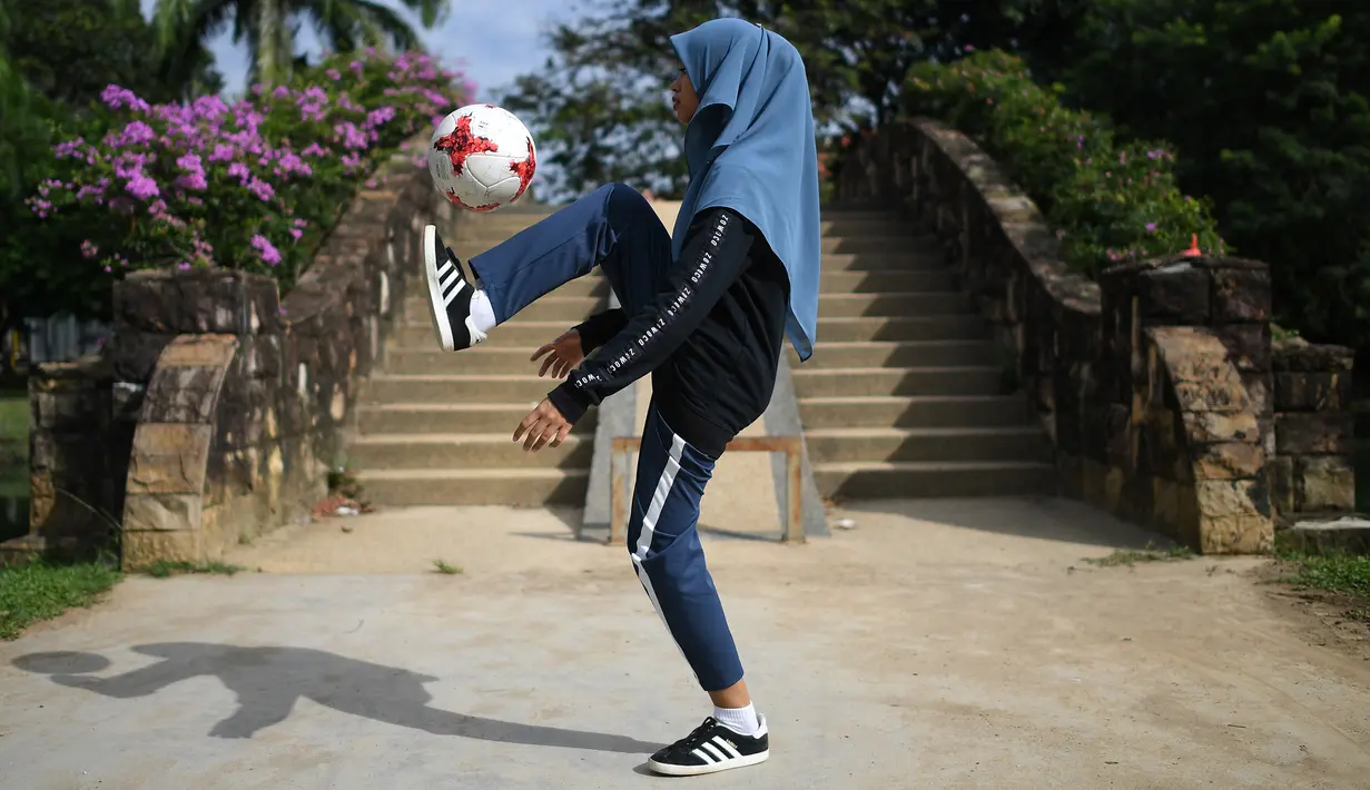 Aksi Qhouirunnisa Endang Wahyudi saat men-juggling bola di sebuah taman di Klang, Kuala Lumpur, (11/7). (AFP Photo/Mohd Rasfan)