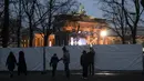 Orang-orang berkumpul di depan pagar saat menyiapkan acara TV di Gerbang Brandenburg di Berlin, Jerman, Rabu (29/12/2021). Perayaan Tahun Baru skala besar telah dibatalkan. (AP Photo/Markus Schreiber)