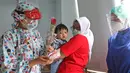 Dokter anak J. Mila Hardiani memberikan bunga dan kue ke pasien di Rumah Sakit Ibu dan Anak Tambak, Jakarta, Selasa (22/12/2020). Pemberian bunga dan kue kepada pasien rawat inap dan pasien yang kontrol dilakukan untuk memperingati perayaan Hari Ibu. (Liputan6.com/Herman Zakharia)