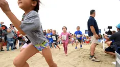 Sejumlah anak saat berpartisipasi dalam 'Tot Trot' selama Nautica Malibu Triathlon di Pantai Zuma di Malibu, California (14/9). (Noel Vasquez / Getty Images untuk Nautica / AFP)