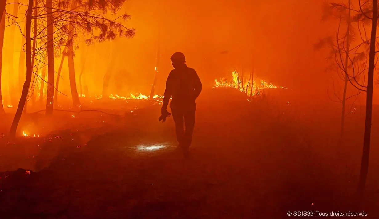Petugas pemadam kebakaran memerangi api dekat Landiras, barat daya Prancis, 17 Juli 2022. Petugas pemadam kebakaran berjuang melawan kebakaran hutan yang berkobar di luar kendali di Prancis dan Spanyol ketika Eropa layu di bawah gelombang panas luar biasa ekstrem. (SDIS 33 via AP)