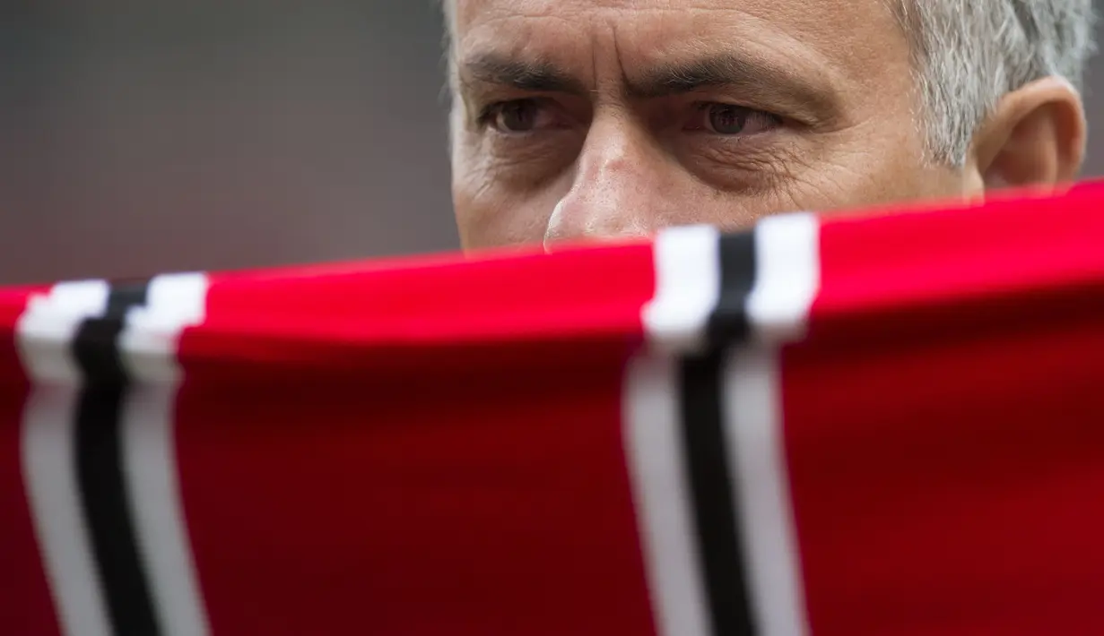 Jose Mourinho berfoto dengan dengan syal Manchester United saat perkenalan di Stadion Old Trafford, Manchester, (5/7/2016). (AFP/Oli Scarff)