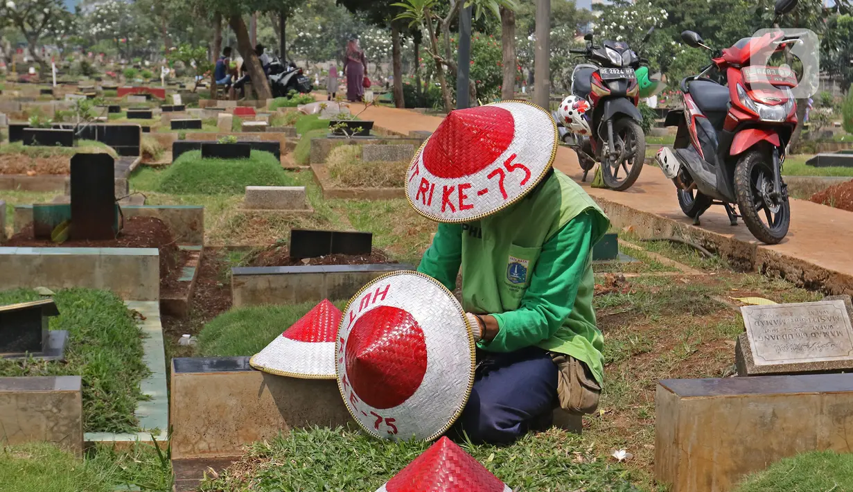 Petugas Pertamanan dan Kehutanan Kota Jakarta Pusat mengenakan atribut kemerdekaan saat menyiapkan caping di TPU Karet Bivak, Jakarta, Minggu (16/8/2020). Para petugas bekerja dengan mengenakan atribut kemerdekaan dalam rangka menyambut HUT ke-75 RI. (Liputan6.com/Herman Zakharia)