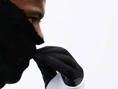 Bek Juventus, Patrice Evra, menutupi hidungnya karena dingin saat latihan jelang laga Liga Champions melawan Sevilla di Vinovo, Italia, Senin (21/11/2016). Cuaca dingin mewarnai latihan Juventus. (AFP/Marco Bertorello)