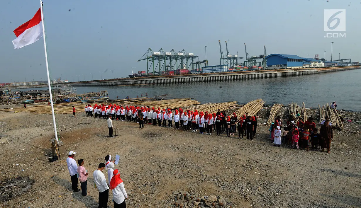 Warga pesisir pantai Cilncing melakukan upacara bendera HUT ke-74 Ri di pinggir pantai, RW 04, Cilincing, Jakarta Utara, Sabtu (17/8/2019). Kegiatan yang diikuti warga RW 08 Manunggal ini diprakarsai Kelas Jurnalistik Cilik dalam rangka memupuk  rasa kebangsaan. (merdeka.com/Arie Basuki)