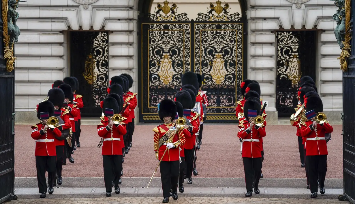 <p>Orang-orang menyaksikan prosesi pergantian penjaga di Istana Buckingham, London, Senin (23/8/2021). Pergantian pasukan jaga yang dilengkapi dengan alat musik lengkap ala marching band tersebut berlangsung untuk pertama kalinya sejak dimulainya pandemi corona Covid-19. (AP Photo/Alberto Pezzali)</p>