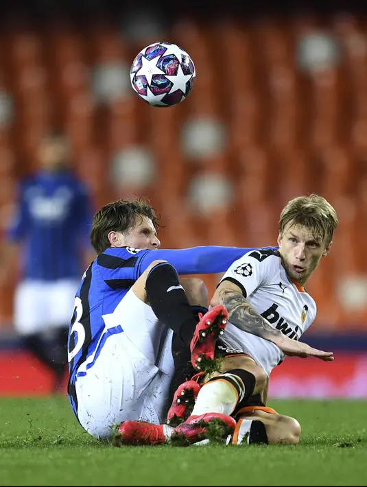 Bek Atalanta, Hans Hateboer berebut bola dengan pemain Valencia, Daniel Wass pada pertandingan leg kedua babak 16 besar Liga Champions di Mestalla, Spanyol (10/3/2020). Atalanta menang 4-3 atas Valencia dan lolos ke perempat final Liga Champions. (UEFA via AP)