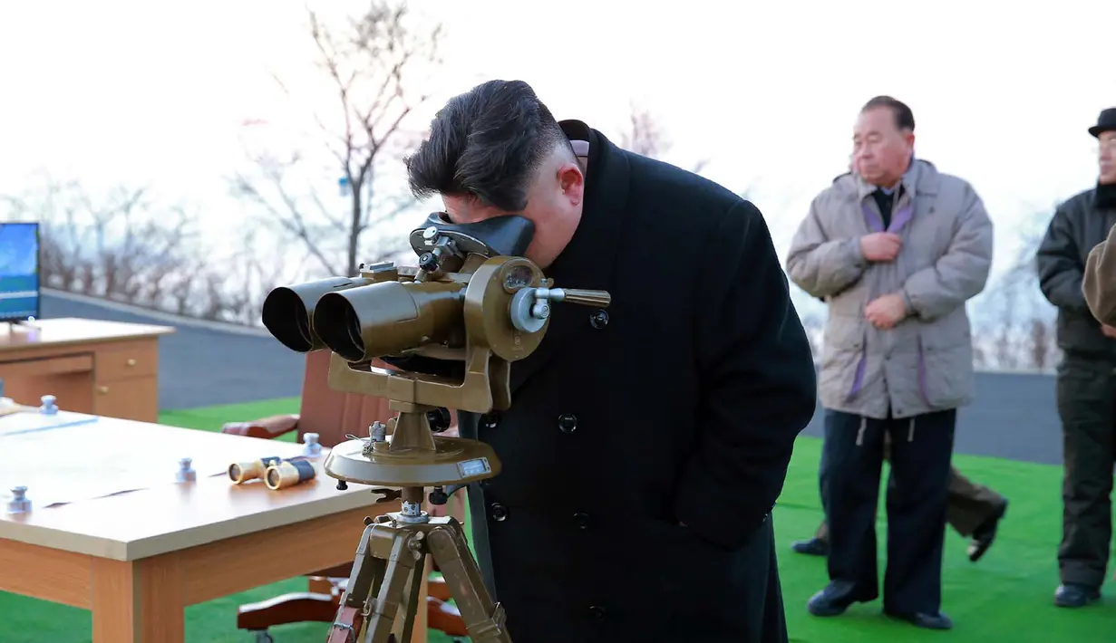Pemimpin Korea Utara, Kim Jong Un melihat peluncuran roket balistik dari unit artileri Hwasong Angkatan Strategis KPA, Pyongyang, Selasa (7/3). (AFP PHOTO/KCNA)