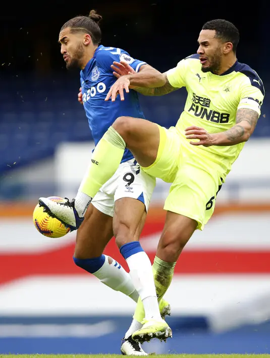 Pemain Newcastle United Jamaal Lascelles (kanan) berebut bola dengan pemain Everton Dominic Calvert-Lewin pada pertandingan Liga Inggris di Goodison Park, Liverpool, Inggris, Sabtu (30/1/2021). Newcastle United menang 2-0. (Clive Brunskill/Pool via AP)