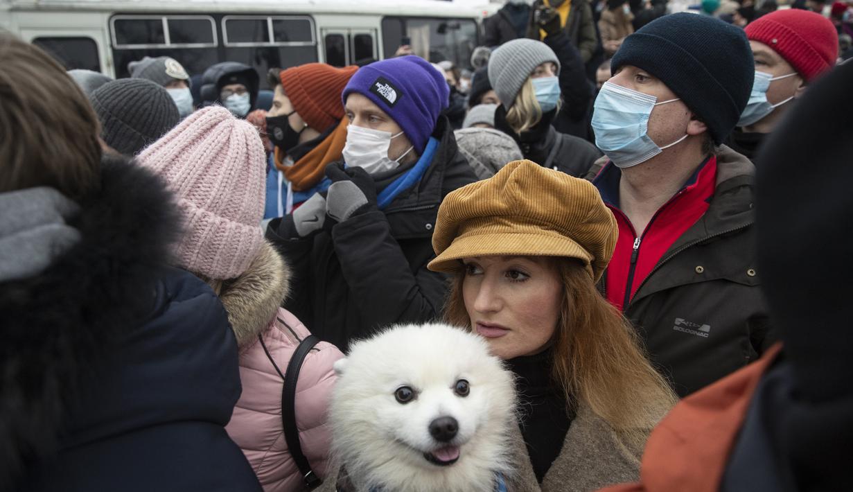 Seorang wanita dengan anjingnya berjalan-jalan di Lapangan Pushkin selama protes terhadap pemenjaraan pemimpin oposisi Alexei Navalny di Moskow, Rusia, Sabtu (23/1/2021). (AP Photo/Pavel Golovkin)