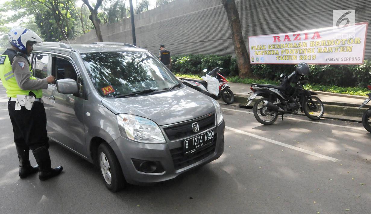 Anggota Satlantas Polres Tangerang Selatan memeriksa kelengkapan surat saat razia pajak kendaraan di Jalan BSD, Tangerang Selatan, Kamis (24/1). Razia ini untuk mendisiplinkan pengendara terhadap pembayaran pajak kendaran. (Merdeka.com/Arie Basuki)