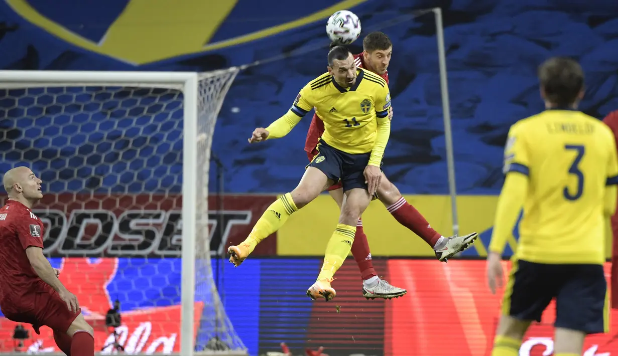 Striker Swedia, Zlatan Ibrahimovic (depan) berduel udara dengan bek Georgia, Lasha Dvali dalam laga Kualifikasi Piala Dunia 2022 Zona Eropa Grup B di Friends Arena, Stockholm, Kamis (25/3/2021). Swedia menang 1-0 atas Georgia. (AFP/Janerik Henriksson/TT News Agency)