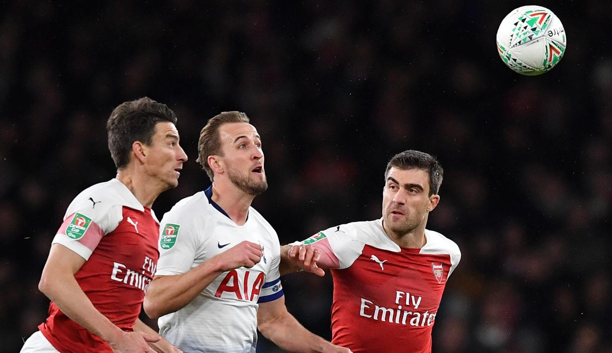 Bek Arsenal, Laurent Koscielny, berusaha merebut bola dari striker Tottenham, Harry Kane, pada laga perempat final Piala Liga di Stadion Emirates, London, Rabu (19/12). Arsenal kalah 0-2 dari Tottenham. (AFP/Ben Stansall)