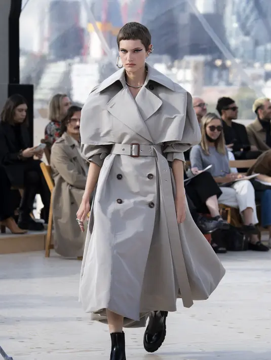 Trench coat berpotongan punggung dari bahan kulit berwarna hitam dan gaun dengan garis leher V yang dalam, memiliki detail belt dan poly taffeta bermotif awan. Foto: Document/Alexander McQueen.