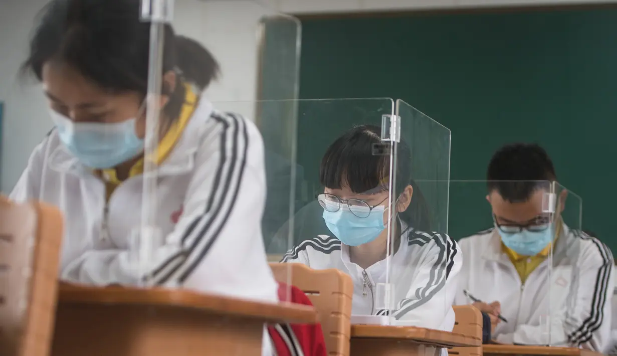 Siswa belajar dengan pemisah pada masing-masing meja mereka sebagai langkah pencegahan penyebaran COVID-19 di Sekolah Menengah No. 23 Wuhan, Wuhan, Provinsi Hubei, China, Rabu (6/5/2020). Sekitar 57.800 siswa tingkat akhir dari 121 SMA dan kejuruan di Wuhan kembali bersekolah. (Xinhua/Xiao Yijiu)