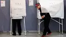 Seorang pria keluar dari bilik suara di sebuah TPS di Seoul, Selasa (9/5). Warga Korea Selatan (Korsel) menggunakan hak suaranya untuk memilih presiden baru setelah pemakzulan Park Geun-hye yang dijerat skandal korupsi. (AP Photo/Ahn Young-joon)
