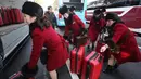 Tim pemandu sorak Korea Utara memasukan koper ke dalam bus saat tiba kantor transit Korea di dekat Zona Demiliterisasi di Paju, Korea Selatan, (7/2). (AP Photo/Ahn Young-joon. Pool)