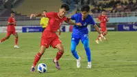 Pemain Timnas Indonesia U-16, Mierza (kiri),&nbsp;mencoba lepas dari kawalan pemain Singapura U-16 pada Piala AFF U-16 2024 di Stadion Manahan, Surakarta, Jumat (21/6/2024) malam WIB. (Bola.com/Radifa Arsa)