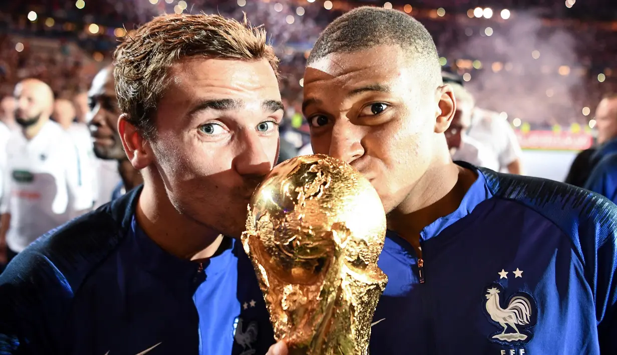 Pemain bintang timnas Prancis, Antoine Griezmann resmi mengumumkan pengunduran dirinya dari sepak bola internasional pada 30 September 2024. Tampak dalam foto, Antoine Griezmann (kiri) bersama Kylian Mbappe saat memenangi laga final Piala Dunia 2018. (FRANCK FIFE/AFP)