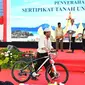 Warga membawa hadiah sepeda yang diberikan oleh Presiden Jokowi saat membagikan sertifikat di GOR Way Handak, Kalianda, Lampung Selatan, Lampung, Minggu (21/1). (Liputan6.com/Pool/Laily Rachev-Biro Pers Setpres)