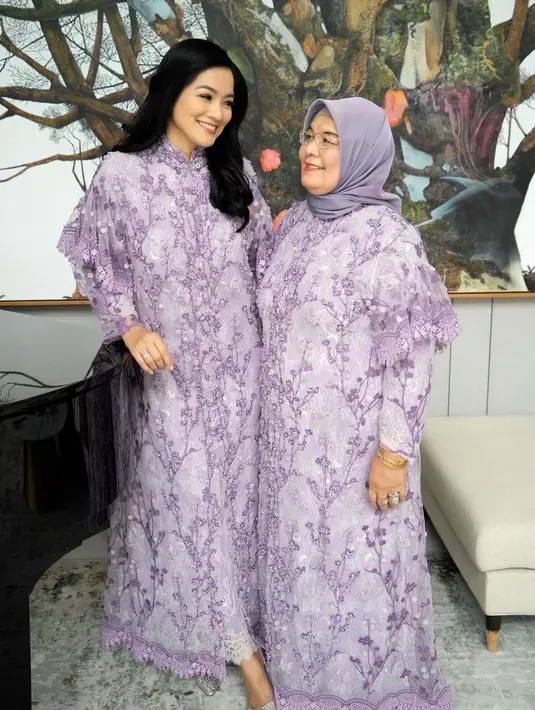 Titi Kamal terlihat luar biasa memesona mengenakan lace dress penuh payet ini. Dress ini memiliki detail kerah cheongsam. Sang ibunda memadukan penampilannya dengan hijab sederhana berwarna abu-abu senada. Foto: Instagram.