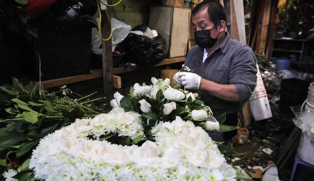 Pedagang membuat karangan bunga sebelum Hari Valentine di tengah pandemi COVID-19 di distrik di Los Angeles, California (12/2/2021). Toko bunga di daerah tersebut sibuk tahun ini dengan pemesanan bunga Hari Valentine dan karangan bunga pemakaman COVID-19. (Mario Tama/Getty Images/AFP)