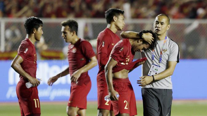 Asisten pelatih Timnas Indonesia U-22, Kurniawan Dwi Yulianto, menghibur Osvaldo Haay usai dikalahkan Vietnam pada laga final SEA Games 2019 di Stadion Rizal Memorial, Manila, Selasa (10/12). Indonesia kalah 0-3 dari Vietnam. (Bola.com/M Iqbal Ichsan)