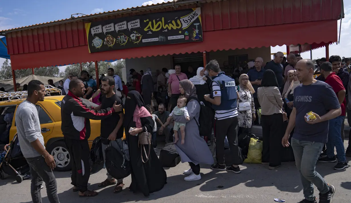 Di Gaza, orang-orang berkumpul di penyeberangan perbatasan Rafah untuk dapat mencapai Mesir untuk menghindari pemboman Israel, berharap penyeberangan itu segera dibuka. (AP Photo/Fatima Shbair)