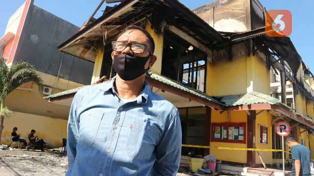 Ketua Stisipol Palu di depan kampus yang terbakar