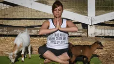 Seorang peserta yang bernama Stephanie Allis berusaha konsentrasi saat melakukan Yoga yang dikelilingi anak kambing di Thousand Oaks, California (4/6). (AFP Photo/Mark Ralston)