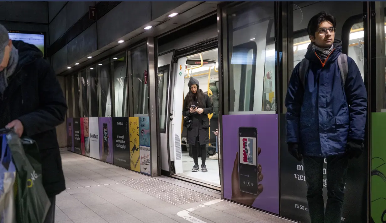 Penumpang berdiri di Stasiun Metro Noerreport di Kopenhagen Denmark, Selasa (1/2/2022). Mulai 1 Februari, negara Skandinavia itu sekali lagi menyingkirkan masker wajah, kartu covid, dan jam buka terbatas untuk bar dan restoran. (Liselotte Sabroe/Ritzau Scanpix via AP)