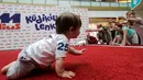 Sejumlah orang tua memberikan semangat kepada bayinya saat mengikuti lomba 'Balap Bayi' di Vilnius, Lithuania (1/6). Lomba ini diadakan dalam rangka memperingati Hari Anak Internasional. (REUTERS/Ints Kalnins)