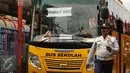 Petugas mengawal bus sekolah untuk mengangkut penumpang di Terminal Blok M Jakarta, Senin (21/12/2015). Bus sekolah dikerahkan untuk mengantisipasi penumpukan penumpang seiring mogoknya sejumlah sopir metromini. (Liputan6.com/Helmi Fithriansyah)