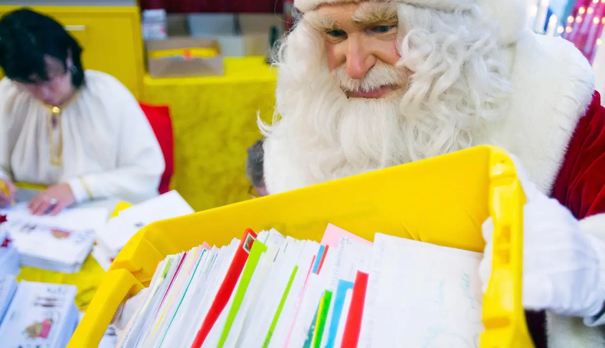 Seorang pria berpakaian Santa Claus membawa surat - surat dari anak - anak di desa Himmelpfort, Jerman, (10/11/2015). Kegiatan  ini dalam rangka menyambut hari Natal. (REUTERS/Hannibal Hanschke)  