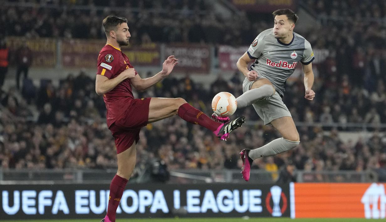 Bek AS Roma, Bryan Cristante berebut bola dengan pemain RB Salzburg, Amar Dedic selama pertandingan leg kedua playoff Liga Europa 2022/2023 di Stadion Olimpico, Jumat (24/2/2023). Kemenangan ini mengantar Roma lolos ke babak 16 besar. Pasukan Jose Mourinho unggul 2-1 secara agregat atas RB Salzburg. (AP Photo/Alessandra Tarantino)