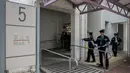 Polisi memasang garis polisi di pintu rumah Law Wan-tung setelah melakukan penyiksaan kepada TKI Erwiana Sulistyaningsih, Hong Kong, (21/01/2014). Polisi berhasil menahan Law Wan-tung saat mencoba kabur ke Thailand. (AFP PHOTO / Philippe Lopez)