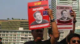 Jurnalis yang tergabung dalam Aliansi Jurnalis Independen (AJI) menunjukkan poster saat menggelar aksi pada Car Free Day di Bundaran HI, Jakarta, Minggu (29/9/2019). Polisi menjeratnya dengan UU ITE atas cuitan Dandhy soal isu Papua. (Liputan6.com/Herman Zakharia)