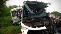 Orang-orang menurunkan penumpang dari bus setelah jatuh di pinggiran Alamo di negara bagian Veracruz, Meksiko. (AP)