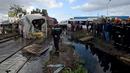 Sejumlah orang berkumpul di lokasi kecelakaan antara kereta dengan sebuah bus di rel dekat wilayah Sidi Fathallah, sekitar 10 km selatan Ibu Kota Tunisia, Rabu (28/12). Penyelidikan tengah dilakukan untuk mencari tahu apa yang terjadi. (Fethi Belaid/AFP)